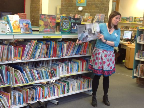 Image of a librarian reading a picture book to the children